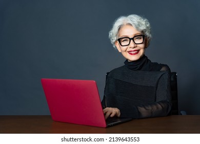 ラップトップ pc を使用してアジアの年配の女性の肖像画。