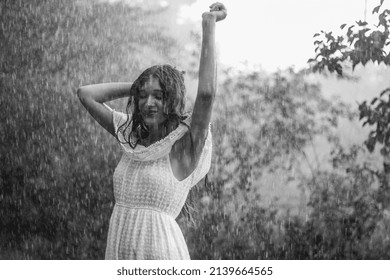 穿著白裙的濕女人在戶外森林雨下跳舞
