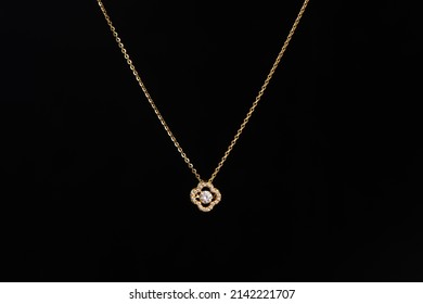 Gjerdan me zinxhir të artë me varëse diamanti në sfond të zi