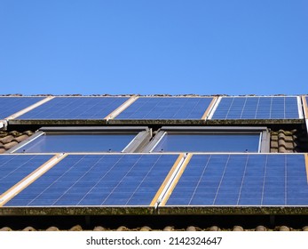 10年以上経過したソーラーパネル。傾斜した天窓の隣にある家族の家の屋根にある太陽光発電システム。ソーラーパネルは窓周りに取り付けました。