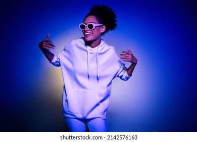 Foto de linda dama adorable vestida con capucha gafas oscuras divirtiéndose bailando aislado fondo de color azul púrpura