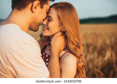 Una pareja tocando la frente siendo romántica y besándose mientras posa bajo la luz del sol con un fondo borroso. Amor y relaciones al aire libre.