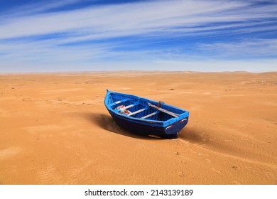 Morocco landscape. Lone blue fishing boat in the desert sand near Essaouira beach.