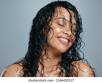 彼女のたてがみを残りについて頭に入れておきます。灰色の背景に対して濡れた髪でポーズをとって魅力的な若い女性のスタジオ ショット。