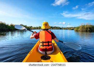 happy woman kayaking with kayak boat in nuture lake behind sea and beach before sunset time for relax and extreme water sport