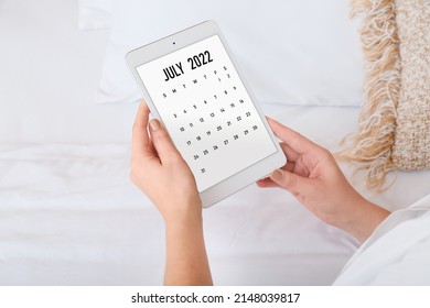Woman with modern tablet computer using calendar application at home