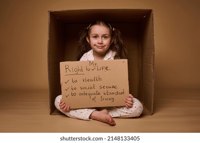 Gelukkig lachend blank meisje met kartonnen poster met sociale boodschap, waarin wordt opgeroepen tot respect voor haar rechten, geïsoleerd op beige achtergrond met kopieerruimte. Wereldkinderdag op 1 juli.