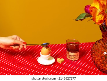 Herbststimmung. Heißer Tee, Ei und Blumen auf roter Tischdecke über gelbem Hintergrund. Frühstückstisch serviert. Food-Pop-Art-Fotografie. Retro-80er, 70er-Stil. Komplementärfarben, Platz für Werbung, Text kopieren