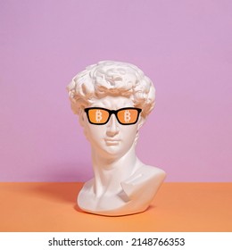 Una estatua de un busto de Roman David con gafas de sol y un símbolo de bitcoin. Blockchain de dinero innovador y criptomoneda en Internet.