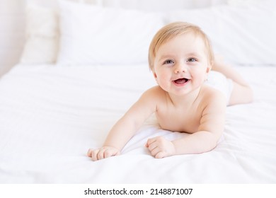 bambino biondo sorridente o che ride con grandi occhi primo piano o ritratto in una culla a casa, il concetto di beni e accessori per bambini