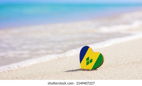 砂浜にハートの形をしたセントビンセントおよびグレナディーン諸島の旗。セントビン セントおよびグレナディーン諸島のリゾートで最高の休暇のコンセプト