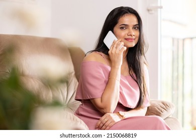 Pretty woman talking in phone at home.