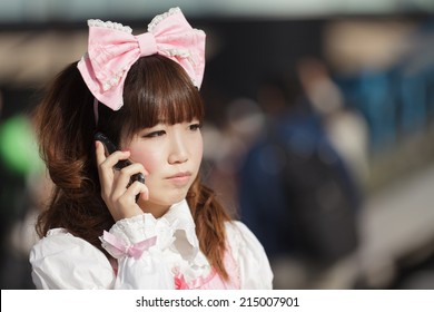 Dona cosplay de lolita japonesa utilitzant el seu telèfon mòbil en un carrer de Tòquio, Japó