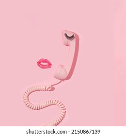 パステル ピンクの背景にピンクのレトロな携帯電話、つけまつげ、キス プリントとバレンタインデーの創造的なレイアウト。80 年代または 90 年代のレトロなファッション美的電話とキスのコンセプト。