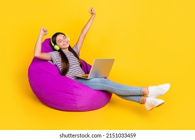 Profilsidebillede af ung pige have det sjovt lyt musik hovedtelefoner melodi sidde blød lilla stol isoleret over gul farve baggrund
