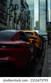 近代的な都市建築を背景に並ぶ駐車車両