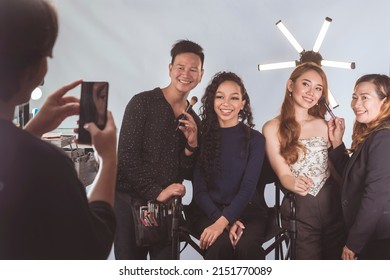 Dos modelos de moda o actrices se toman selfies con su maquillador y estilista.