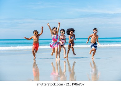 多様性の小さな男の子と女の子の友人のグループが、夏休みに一緒に熱帯のビーチで海の水で走り、遊んでいます。幸せな子供の子供は、ビーチでの休暇にアウトドア ライフ スタイルを楽しんで楽しんでいます。