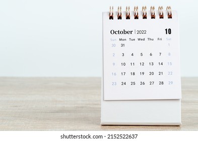 Lịch để bàn tháng 10 năm 2022 trên nền gỗ.