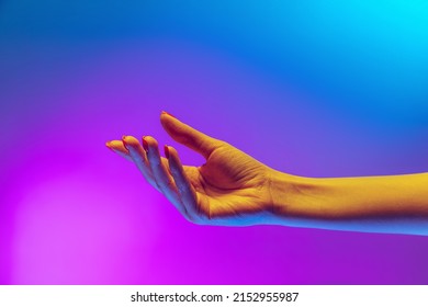 Pregària. Imatge d'estudi d'una mà humana estètica aïllada sobre fons blau-morat degradat amb llum de neó. Concepte de relació humana, comunitat, art, simbolisme, cultura i història