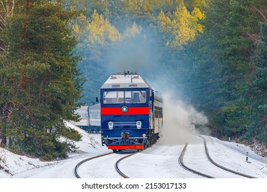 Passenger intercity express train rushes through the snowy forest. Close-up view.