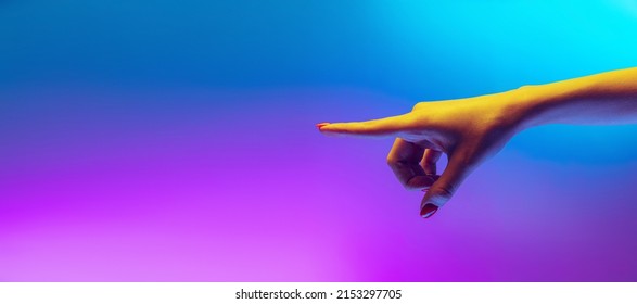 Apuntant. Imatge d'estudi d'una mà humana estètica aïllada sobre fons blau-morat degradat amb llum de neó. Concepte de relació humana, comunitat, art, simbolisme, cultura i història