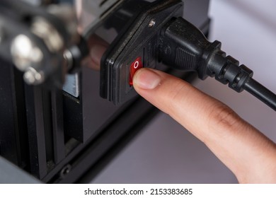 人間の手で 3D プリンターの電源ボタンを押し、3D プリンターのスイッチに接写し、ボタンを押すマクロショット、産業用機械と技術装置、平面図、限定フォーカス