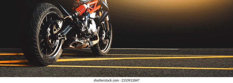 夜間にアスファルト道路に一人で駐車したオートバイ、水平コピースペース、オートバイのパノラマバナーコンセプト