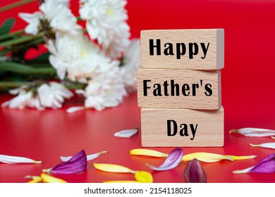 Text auf Holzwürfel und mit Blume auf rotem Hintergrund - Happy Father's Day. Veranstaltung und Feiern.