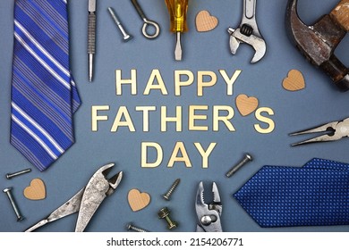 Mensaje del Día del Padre Feliz con marco de lazos y herramientas sobre un fondo de papel azul gris. Vista aérea.