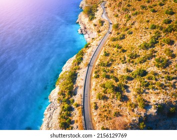 Nhìn từ trên không của con đường núi gần biển xanh với bãi biển đầy cát vào lúc hoàng hôn vào mùa hè. Oludeniz, Thổ Nhĩ Kỳ Nhìn từ trên xuống đường, cây cối, nước trong xanh, núi non. Phong cảnh đẹp với đường cao tốc, đá, bờ biển
