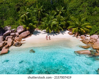 Anse Lazio Praslin Seychellen, ein junges Paar von Männern und Frauen an einem tropischen Strand während eines Luxusurlaubs auf den Seychellen. Tropischer Strand Anse Lazio Praslin Seychellen