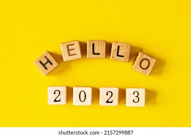 2023 woord is gemaakt van houten blokken op de gele achtergrond. Gelukkig nieuwjaar. Nieuw jaar en vakantieconcept.