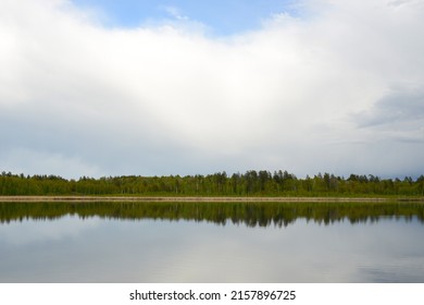 湖、森、雲。雨天時の森の湖、池、川の美しい景色。湖の水面に映る雲の反射。湖と森の穏やかな風景
