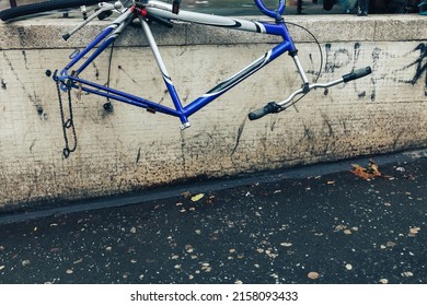 Verlassenes zerstörtes Fahrrad mit fehlenden Rädern und Sattel auf der Stadtstraße
