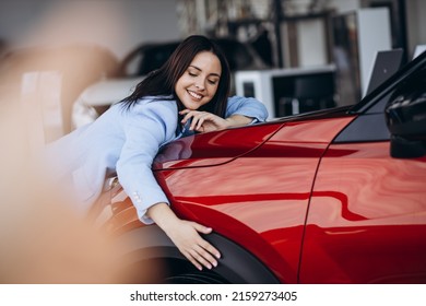Žena grli svoj novi crveni auto