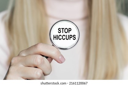 STOP HICCUPS-inscriptie op de stethoscoop in de handen van een vrouwelijke arts, medisch concept
