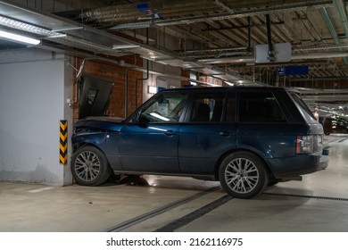 巨大なSUV車が高速で地下駐車場の壁のドアを通り抜け、運転手と乗客は事故現場を去った