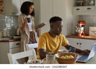 Joven pareja multiétnica haciendo diferentes cosas en el desayuno por la mañana.
