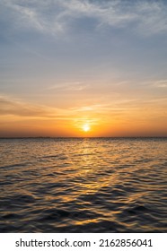 Las nubes del cielo del atardecer verticales sobre el mar por la noche con la colorida luz del sol naranja se reflejan en el paisaje marino con el concepto de viaje de verano