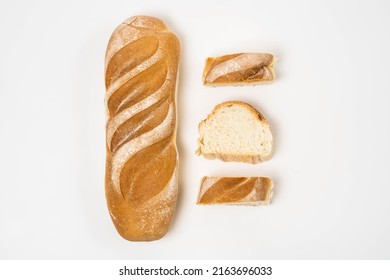 Toasted loaf of bread on white background with side slices, overhead view. food concept