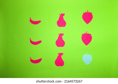 緑の背景にピンクの紙の果物と1つの青い紙のイチゴ、クリエイティブアートデザイン、ビタミン、最小限のコンセプト