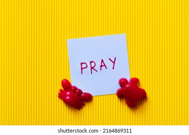 tampilan atas kartu dengan tulisan doa di dekat mainan kepiting merah dan kura-kura dengan latar belakang kuning