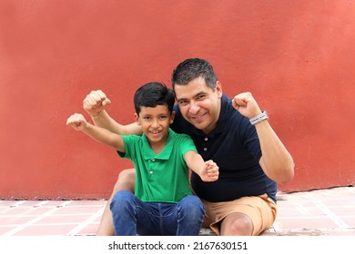 Alleenstaande vader en donkerharige Latino-zoon spelen en hebben samen plezier en brengen quality time met het gezin door op Vaderdag om de overwinning te vieren met knuffels en kusjes