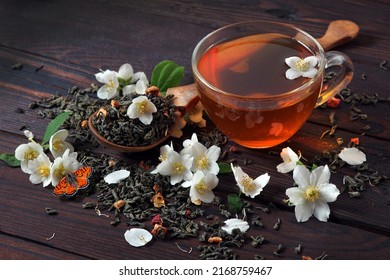 rode vlinder op jasmijnbloemen. groene thee met jasmijn op tafel. groene theeblaadjes, jasmijnbloemen en kopje thee close-up