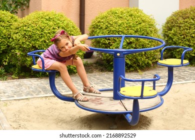 Retrato de una niña de seis años en el patio de recreo de verano