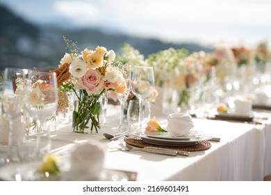 Lindas flores decorando a mesa. Mesas postas para um evento, festa ou recepção de casamento. Jantar luxuoso e elegante em um restaurante. Copos e pratos. Momento sofisticado, tempo especial.