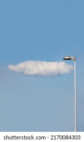 Đèn cao với một đám mây trắng đơn giản bên dưới trên bầu trời xanh làm nền. Khí hậu, dự báo thời tiết, điện, năng lượng, điện, khái niệm môi trường. Hôm nay trời có mưa không
