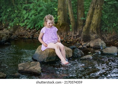 暖かく晴れた夏の日に川で楽しんでいるかわいい幼児の女の子。フォレスト ストリーム クリークで水しぶきを上げて幸せな興奮した未就学児。