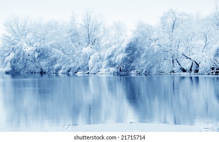 Snow covered trees reflected in the river
